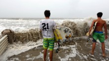 Adam and Alec Selent watch waves crash over a retainer wall at the Ocean Club condominiums in Isle of Palms, South Carolina, on October 7.