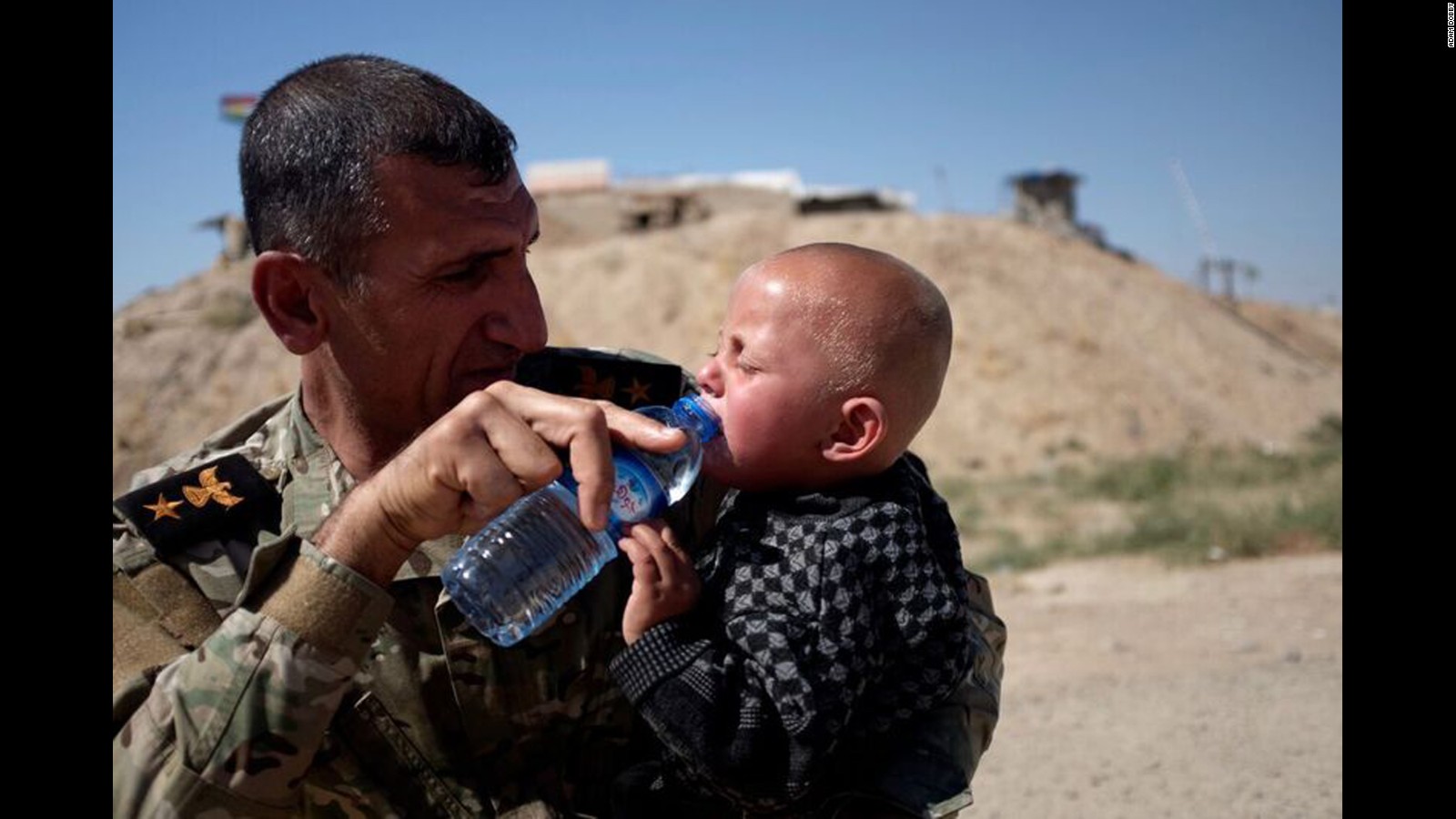 Peshmerga Commander Araz Abdal Rahman gives water to a child at Daqouq.