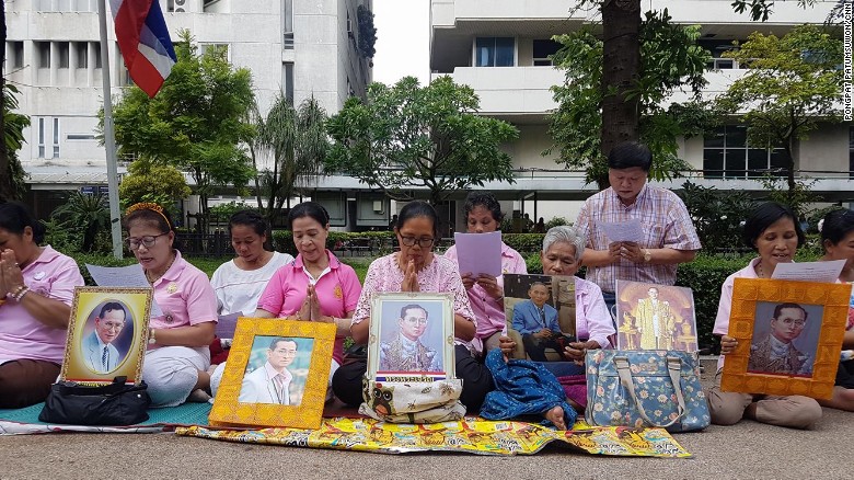 A group of women hold a vigil for King Bhumibol outside Siriraj Hospital.