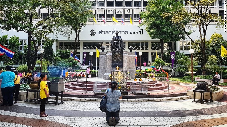 A woman prays for King Bhumibol&#39;s speedy recovery outside Siriraj Hospital.