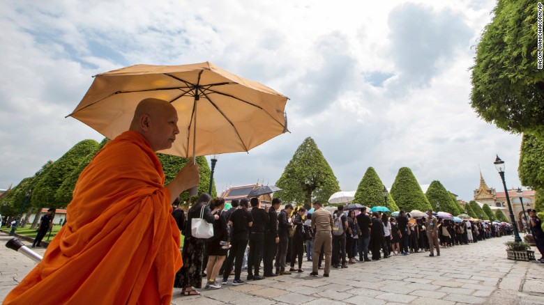 A Buddhist monk stands next to line of mourners waiting to pay their respects to the body of the late King Bhumibol Adulyadej at the Grand Palace in Bangkok, Thailand Saturday, October 15, 2016. Thais in their thousands, dressed in somber black and white, descended on the Grand Palace to pay respects to Bhumibol, who died on Thursday.