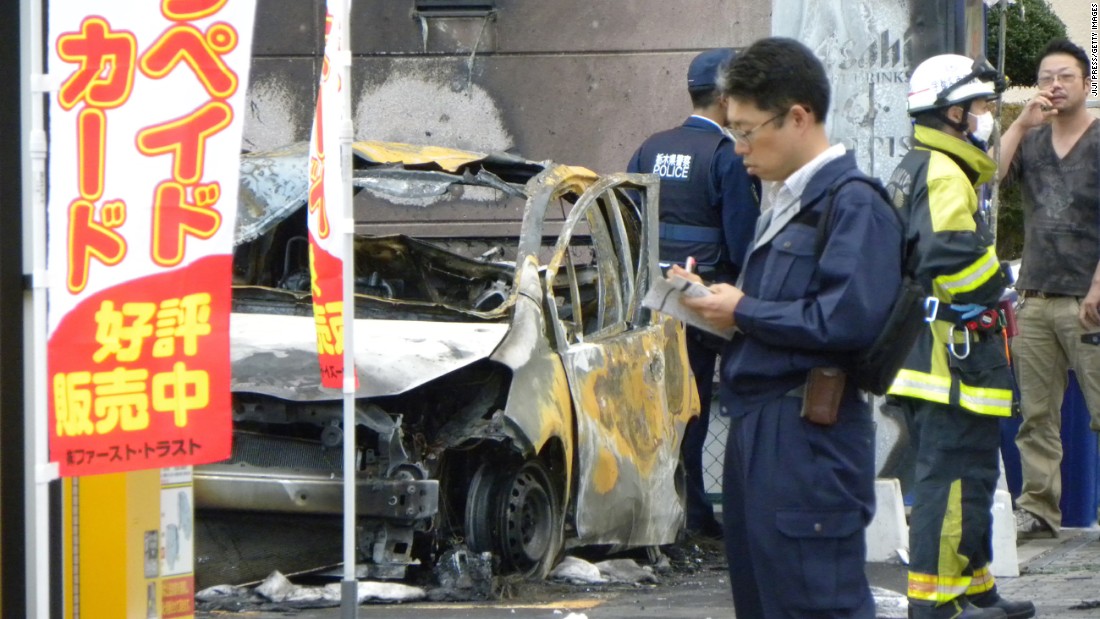 Policemen and firefighters investigate a parking lot after an explosion in Utsunomiya, some 100 kilometres (60 miles) north of Tokyo, on October 23, 2016.