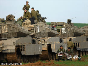 A column of Israeli armored vehicles is deployed in a farmer's field Tuesday near the Gaza border.