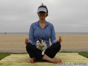 Tara Brown practices yoga with Lucky Cat in Venice Beach, California.