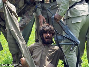Pakistani paramilitary soldiers arrest a suspected militant near the site of a police training center in Lahore.