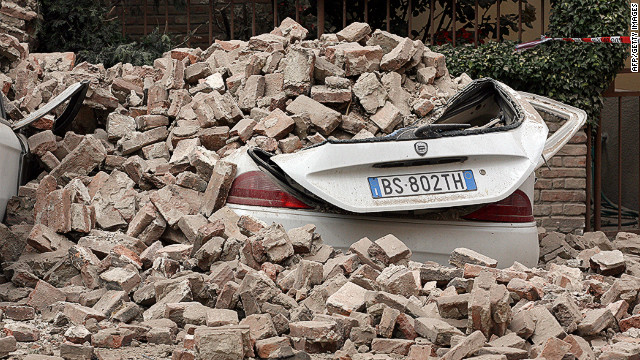 Cars are left buried under rubble from Sunday's earthquake in Finale Emilia. 