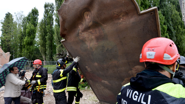 Firefighters recover a painting from a church that was destroyed by the quake in the village of San Carlo, Italy.