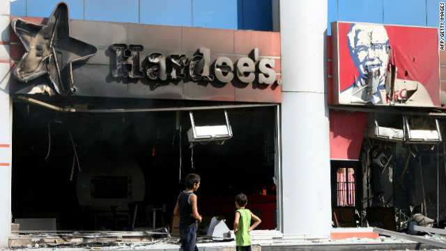 Boys inspect fast food chains Hardee's and KFC after they were torched during a protest in the northern Lebanese city of Tripoli on Friday.