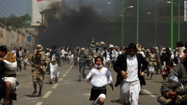 Yemeni protesters run for cover from tear gas fired by riot police in Sanaa on Friday.
