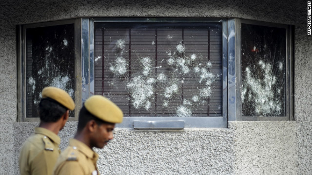Indian policemen walk past smashed windows of the U.S. Consulate building, caused by a mob of demonstrators protesting against an anti-Islam film, in Chennai, India, on Friday, September 14.