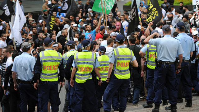 Police stand guard near protesters near the U.S. Consulate General in Sydney on Saturday, September 15.