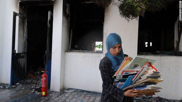 A woman collects books from a classroom in the American school in Tunis on Saturday.