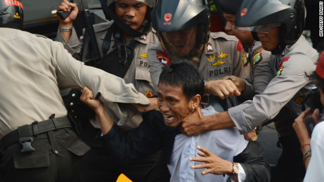 Indonesian anti-riot police arrest a protester Monday outside the U.S. Embassy in Jakarta. Monday's demonstrations come nearly a week after protests erupted in Egypt and Libya, spreading to more than 20 nations.
