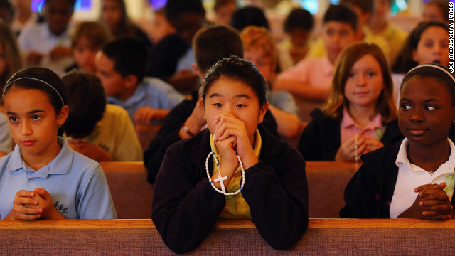 Students participate in a prayer service for victims of the Newtown, Connecticut, mass shooting at St. Rose of Lima School in Miami on Friday, December 21.