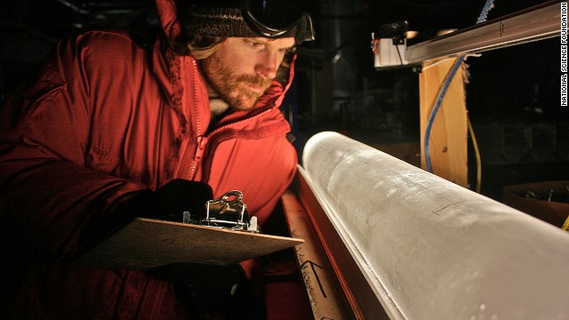 A scientist looks at an ice core from the West Antarctic Ice Sheet Divide coring site.