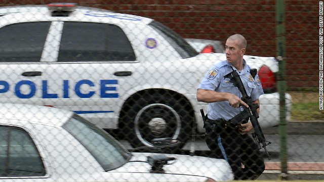 A police officer runs near the scene of the shooting rampage at the Washington Navy Yard on Monday, September 16. Authorities said at least 12 people -- and the suspect -- were killed in the shooting.