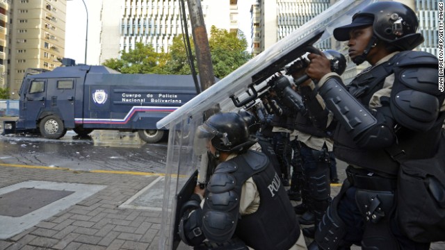 Members of the National Police protect themselves during a protest in Caracas on February 19.