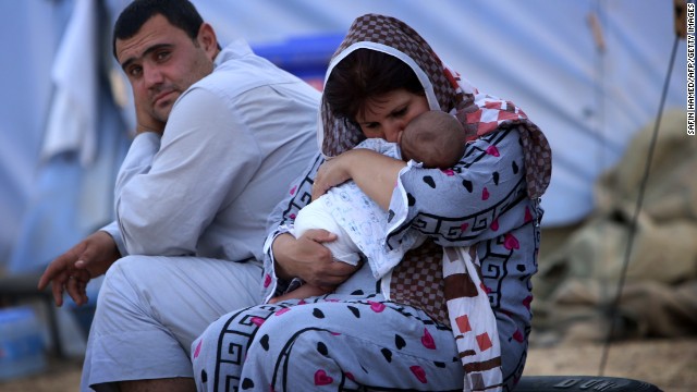 A woman cradles her baby Thursday, June 12, at a temporary camp set up in Aski Kalak, Iraq, to shelter those fleeing the violence in northern Nineveh province. More than 500,000 people fled in fear after extremist militants overran Mosul, Iraq's second-largest city, on June 10, the International Organization for Migration said.