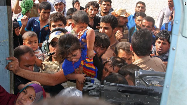 Iraqi Shiite Turkmens, mostly women and children, try to board an Iraqi Army helicopter aid flight bringing in supplies to the town of Amerli, Iraq, on Saturday, August 30. Amerli had been surrounded by fighters from the terror group ISIS since mid-June, but on Sunday the siege was broken by Iraqi security and volunteer forces, according to retired Gen. Khaled al-Amerli, an Amerli resident and member of its self-defense force.