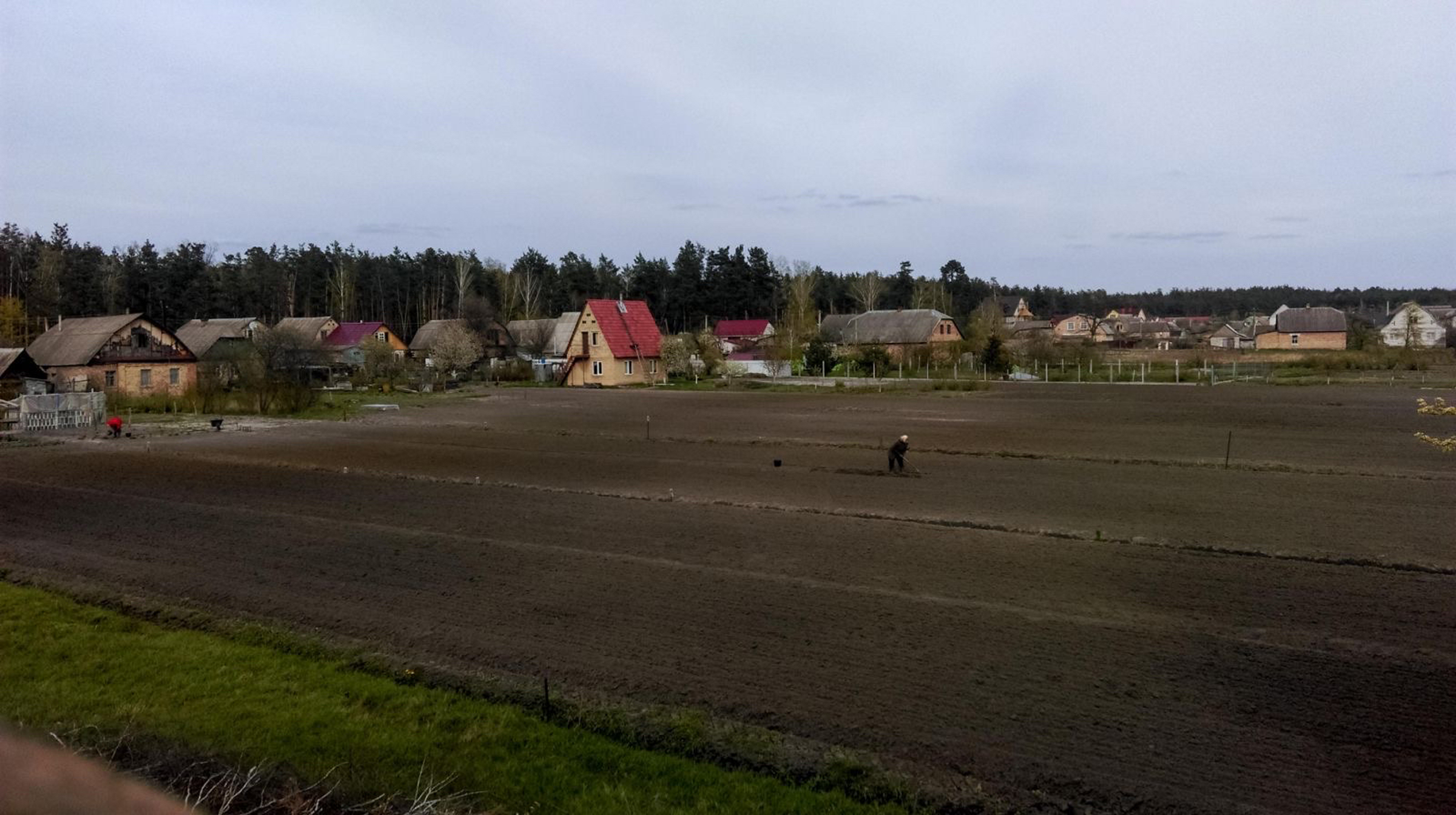 A bare field with houses in the background