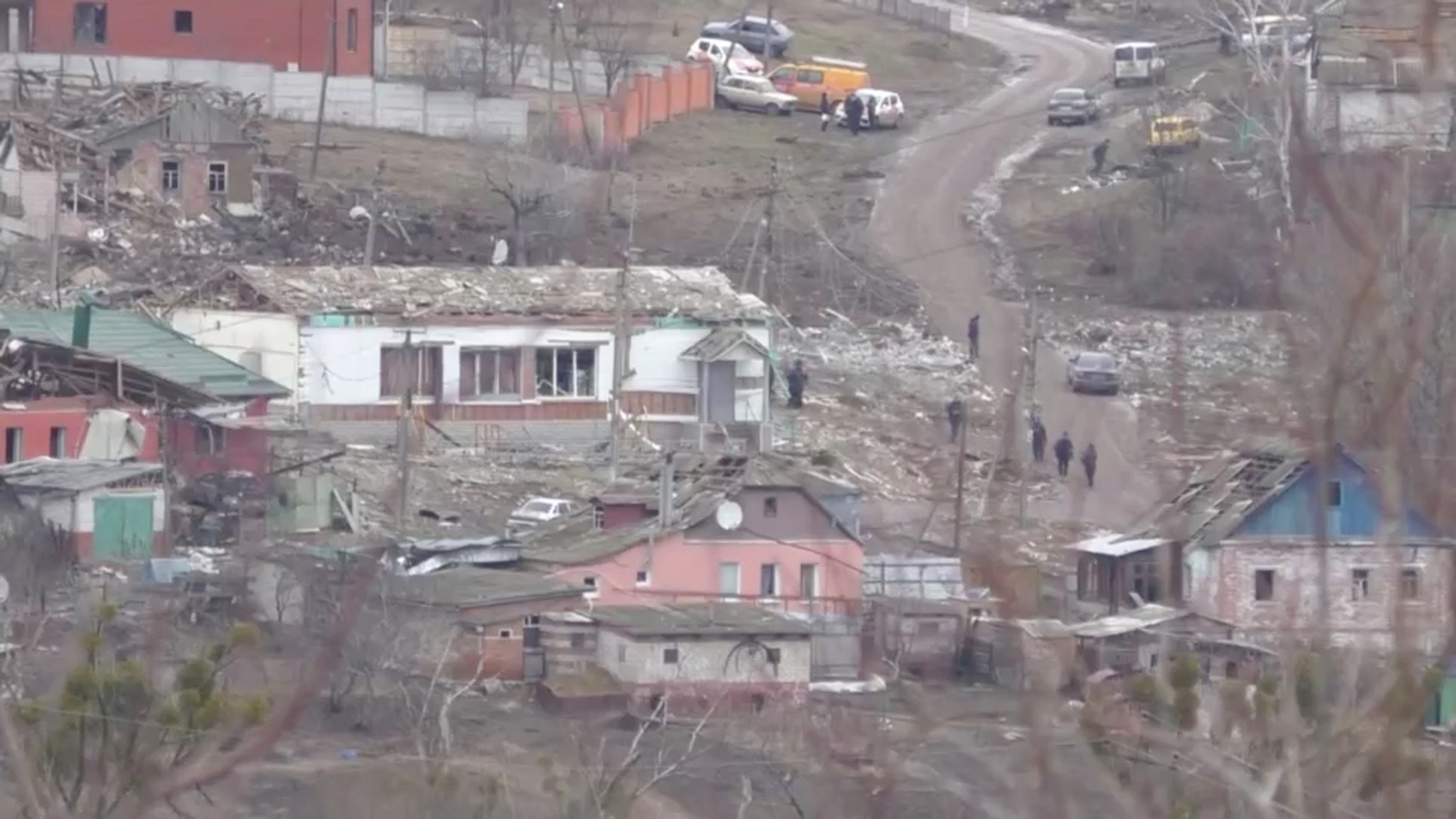 the same scene of houses but they are destroyed with rubble everywhere