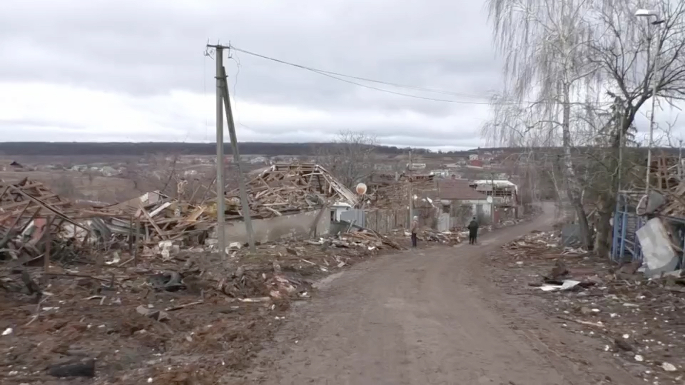 Wood and rubble along a road where houses once stood