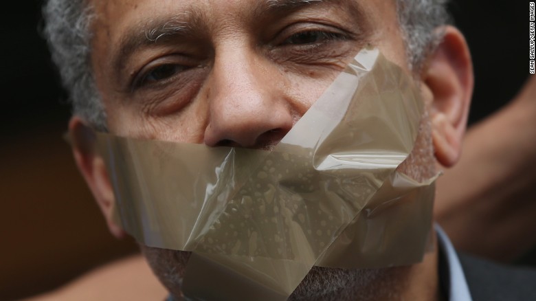 A protester demanding freedom for Al Jazeera reporter Ahmed Mansour stands with his mouth taped shut to symbolize the persecution of journalists in Egypt outside the court and prison where Mansour is being held on June 22, 2015 in Berlin, Germany.