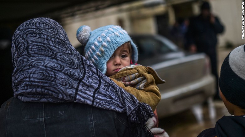 Syrian refugees await their fate near the Turkish border gate as they flee the northern embattled city of Aleppo on February 6, 2016.