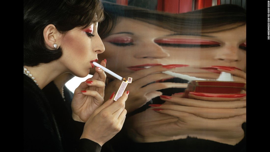 Model and actress Anjelica Huston lights a cigarette in front of a large mirror in 1972. This is one of more than 30,000 unseen photos released by Conde Nast, the magazine house behind Vogue, GQ and Vanity Fair.