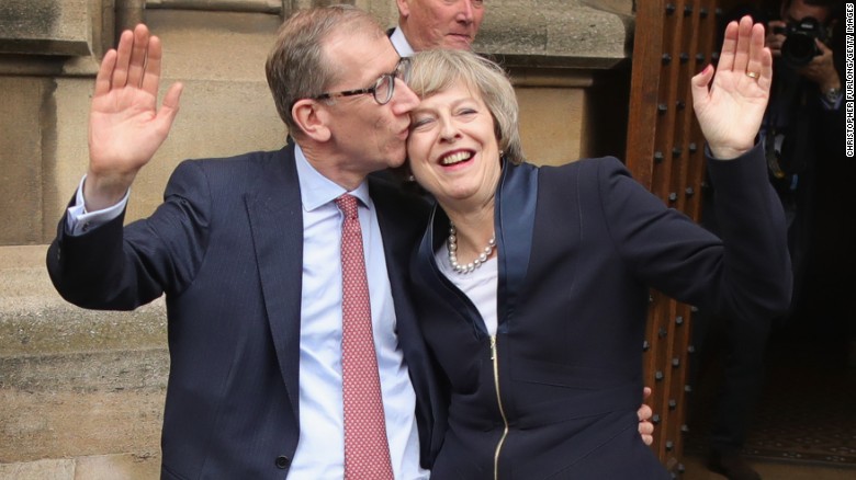 Philip May gives his wife a kiss Monday before she speaks about assuming party leadership. 
