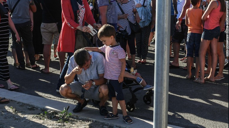 A young boy comforts his father Saturday on the Promenade des Anglais in Nice.
