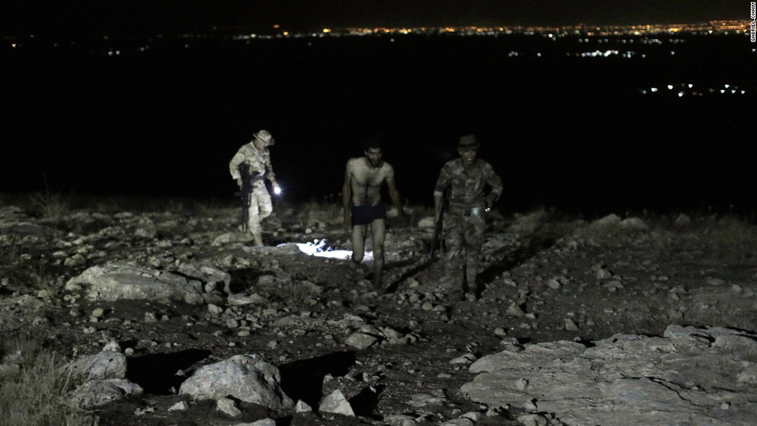 A man approaches soldiers after stripping down to his underwear.