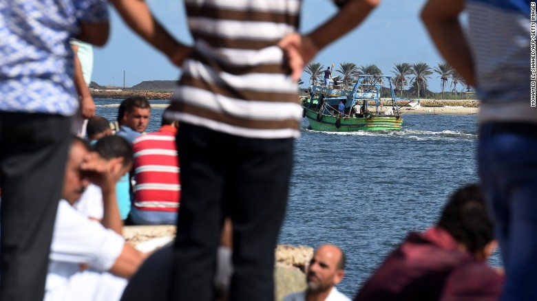 Egyptian men sit along the shore in the Egyptian port city of Rosetta on September 22, 2016 as they watch a boat departing for a search operation.
