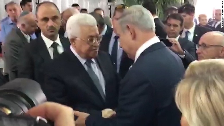 Abbas, Netanyahu shake hands at service