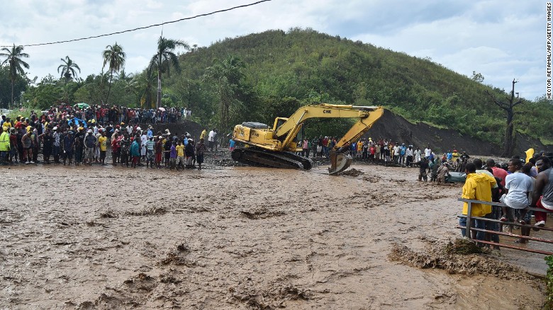 Haitians wait to cross the river n Petit Goave where a bridge collapsed cutting off a main route to the devastated south of the country 