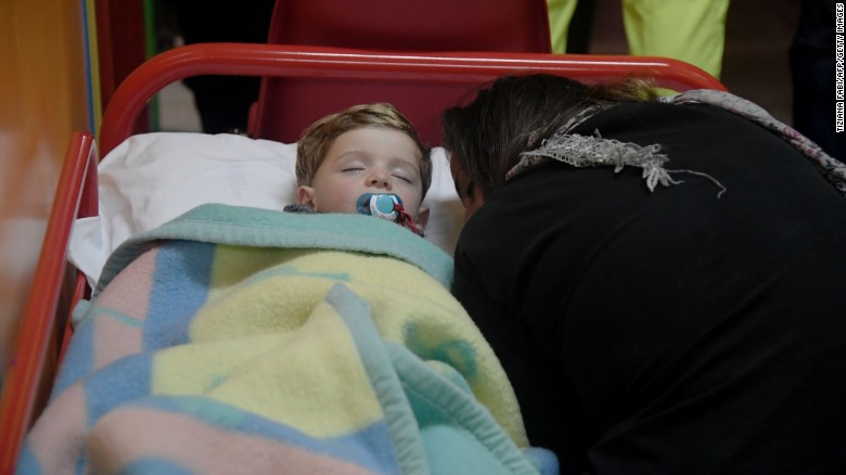 A child sleeps in a secured area of Visso after earthquakes rocked central Italy.