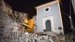 The Church of San Sebastiano stands amidst damaged houses in Castelsantangelo sul Nera, Italy, Wednesday, Oct 26, 2016 following an earthquake,. A pair of strong aftershocks shook central Italy late Wednesday, crumbling churches and buildings, knocking out power and sending panicked residents into the rain-drenched streets just two months after a powerful earthquake killed nearly 300 people. (AP Photo/Sandro Perozzi)