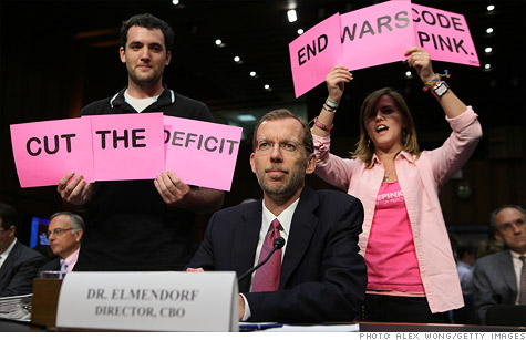 Before the debt committee hearing began Tuesday, protesters held up signs in view of committee members. CBO Director Douglas Elmendorf was the only witness to testify.
