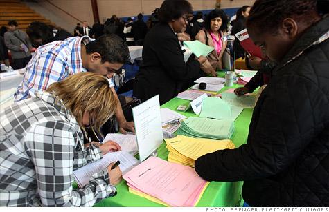 Job seekers fill out applications at a job fair in Queens, New York.