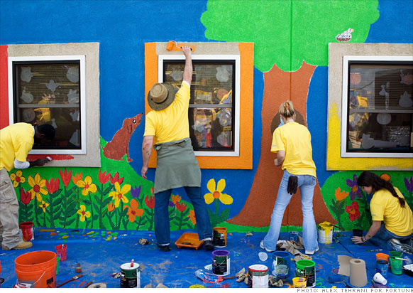 Volunteers paint a building at the Alliance For Progress Charter School in Philadelphia.